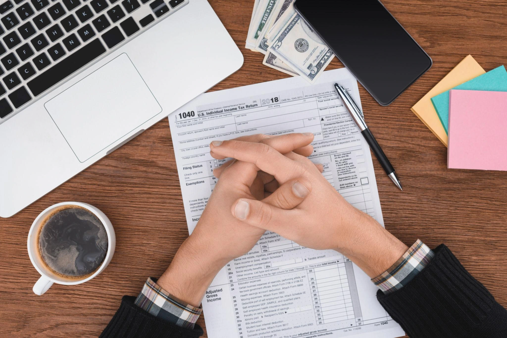 Individual tax filing services with taxpayer reviewing 1040 form and financial documents.